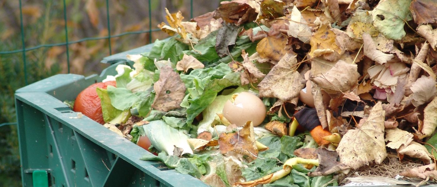 esenski kompostni kup, prekrit s plastjo listja in zemlje