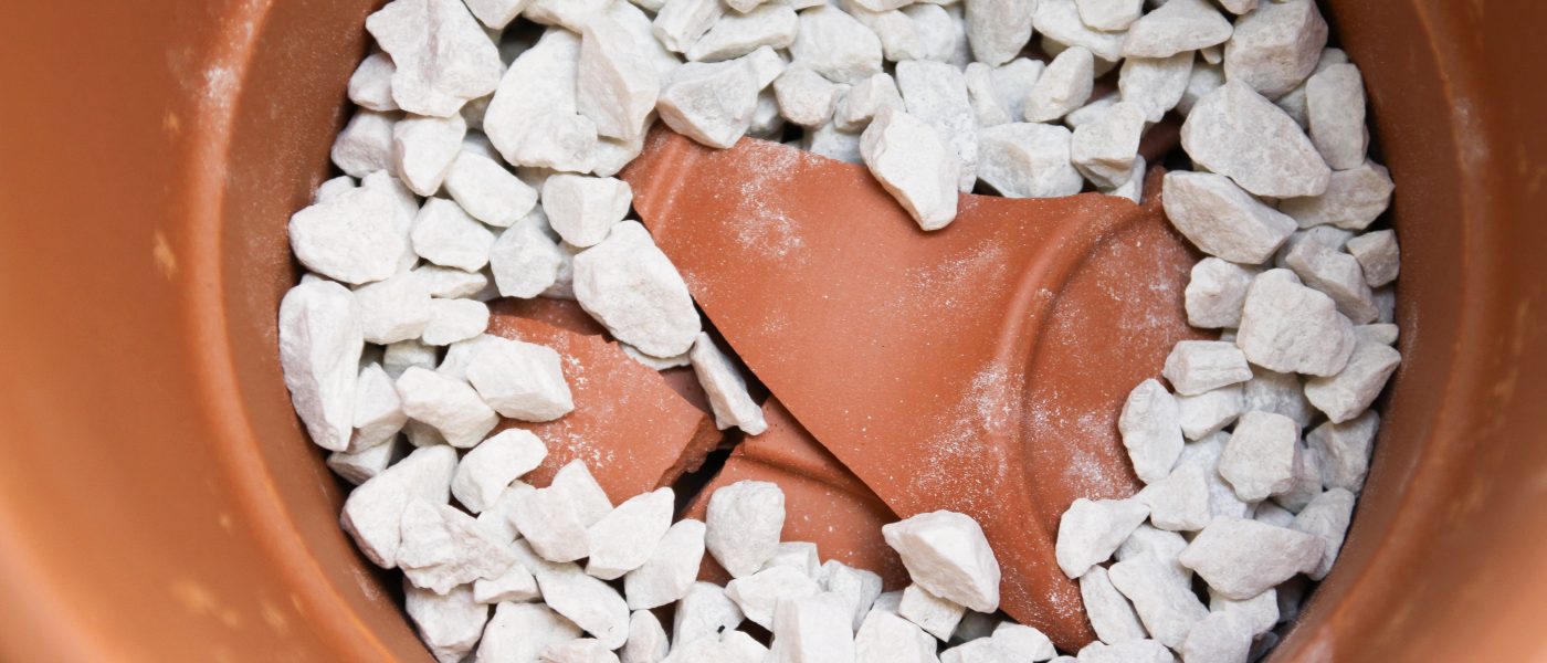 Drenažni sloj iz črepinje in kamenja na dnu keramične posode